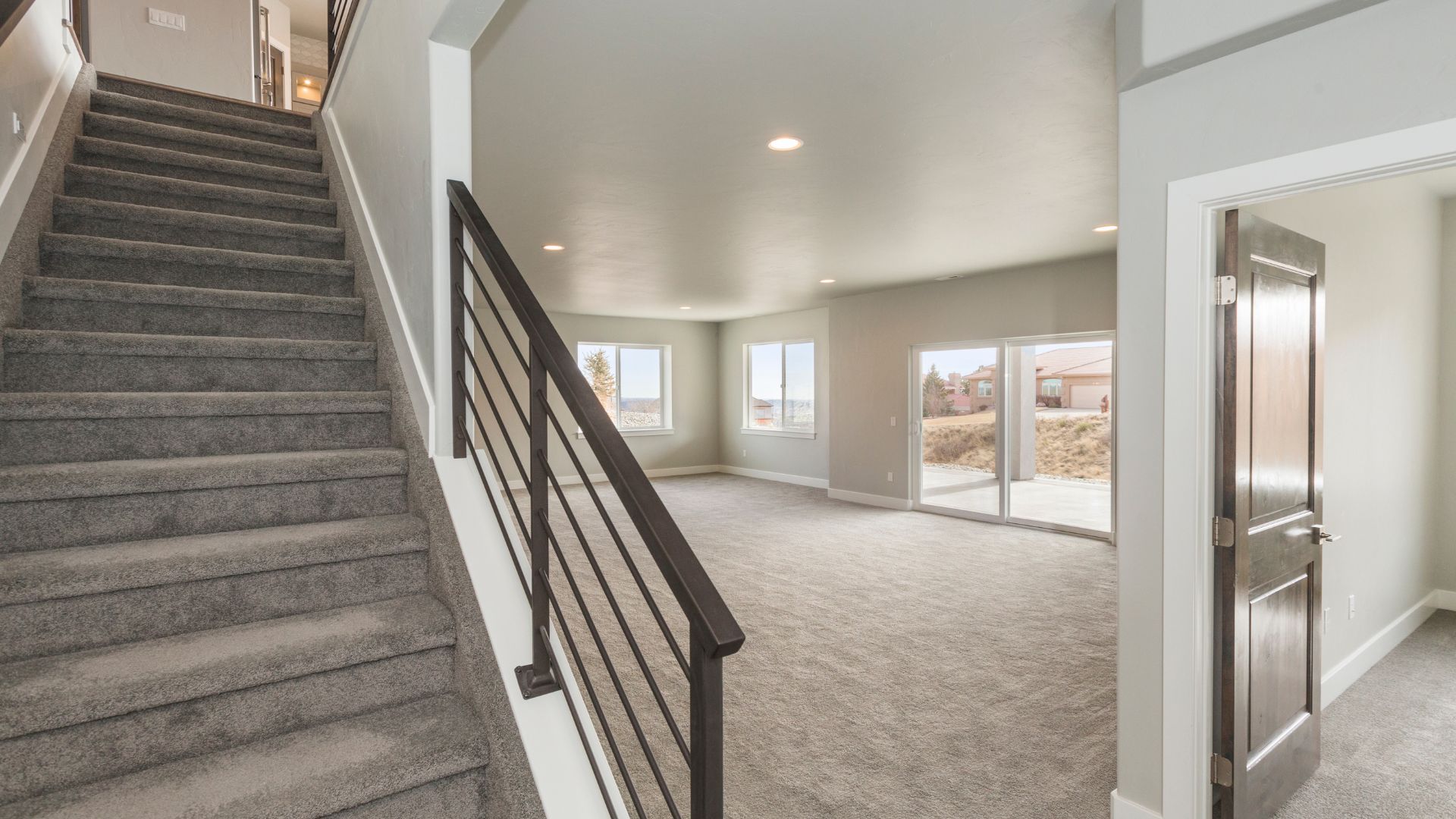 A large empty room with a staircase leading up to the second floor