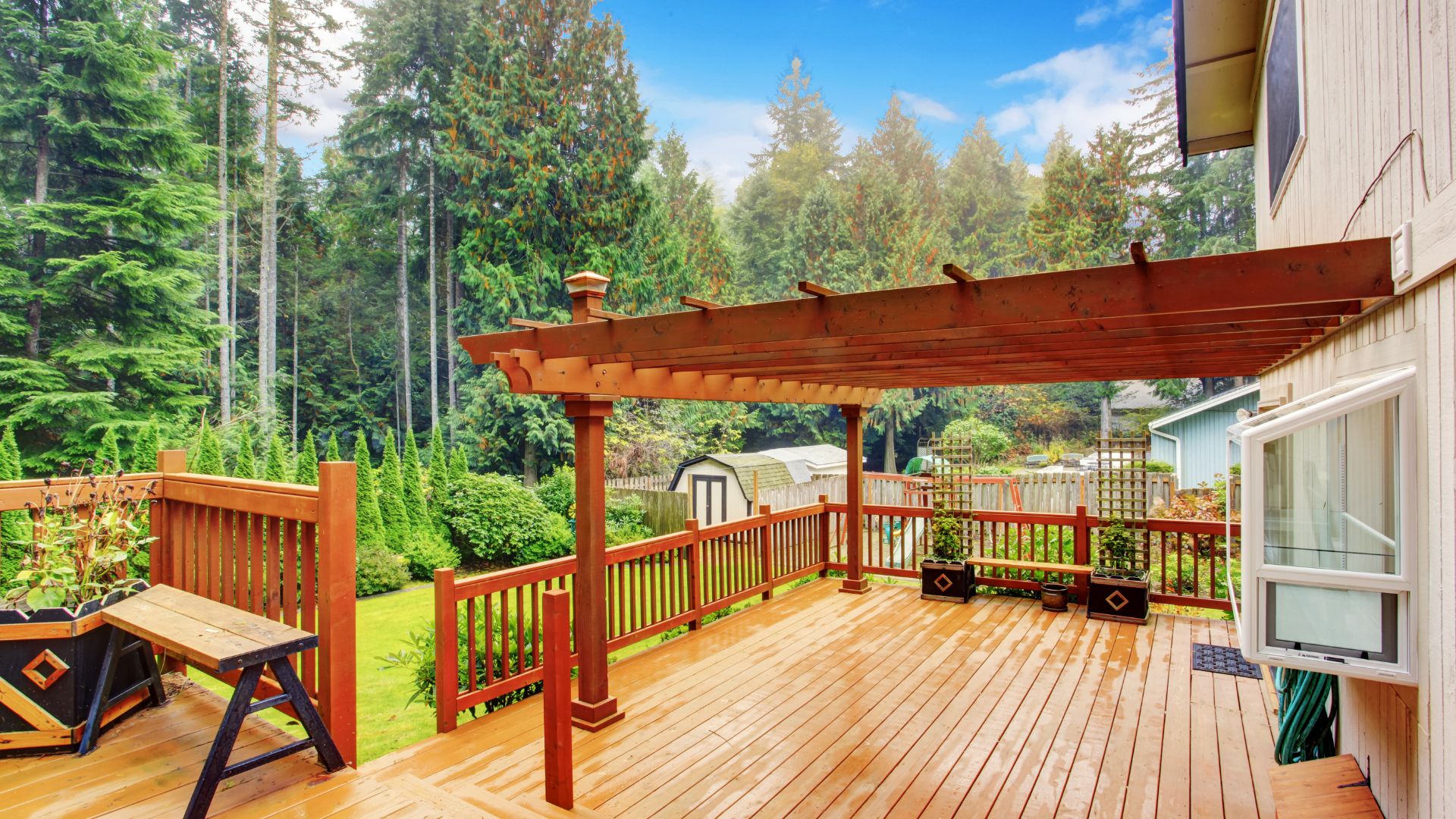 A wooden deck with a picnic table and bench