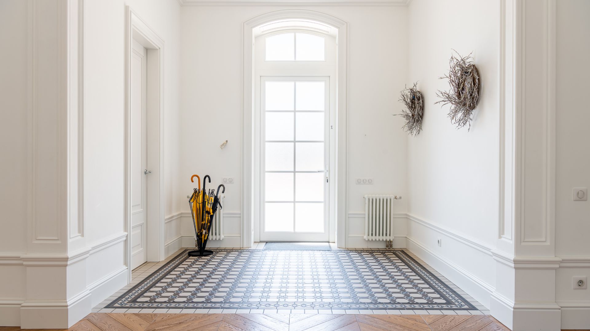 A hallway with a tiled floor and white walls