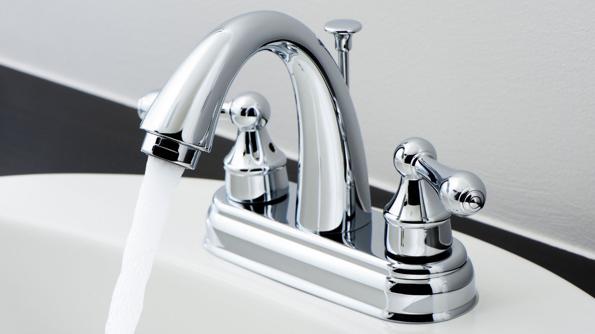 A chrome faucet with water running from it